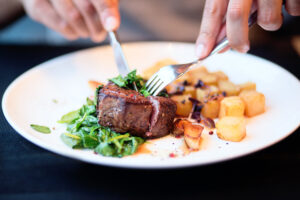 Diner cuts into steak at one of the best Granbury restaurants.